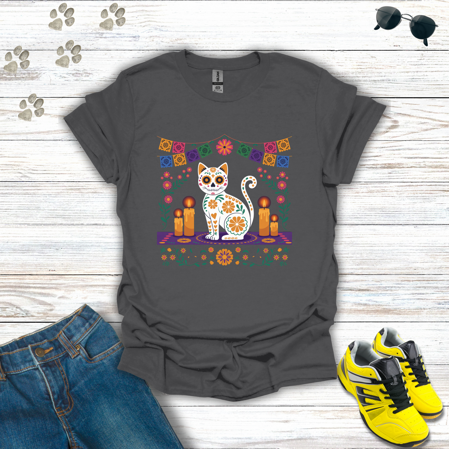 Charcoal t-shirt with a cat and candle design on a wooden surface with jeans and shoes.