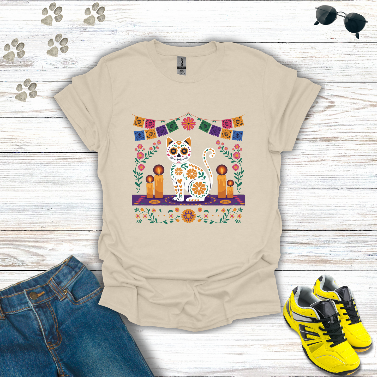 Natural t-shirt with a colorful cat design on a wooden surface with jeans and shoes.
