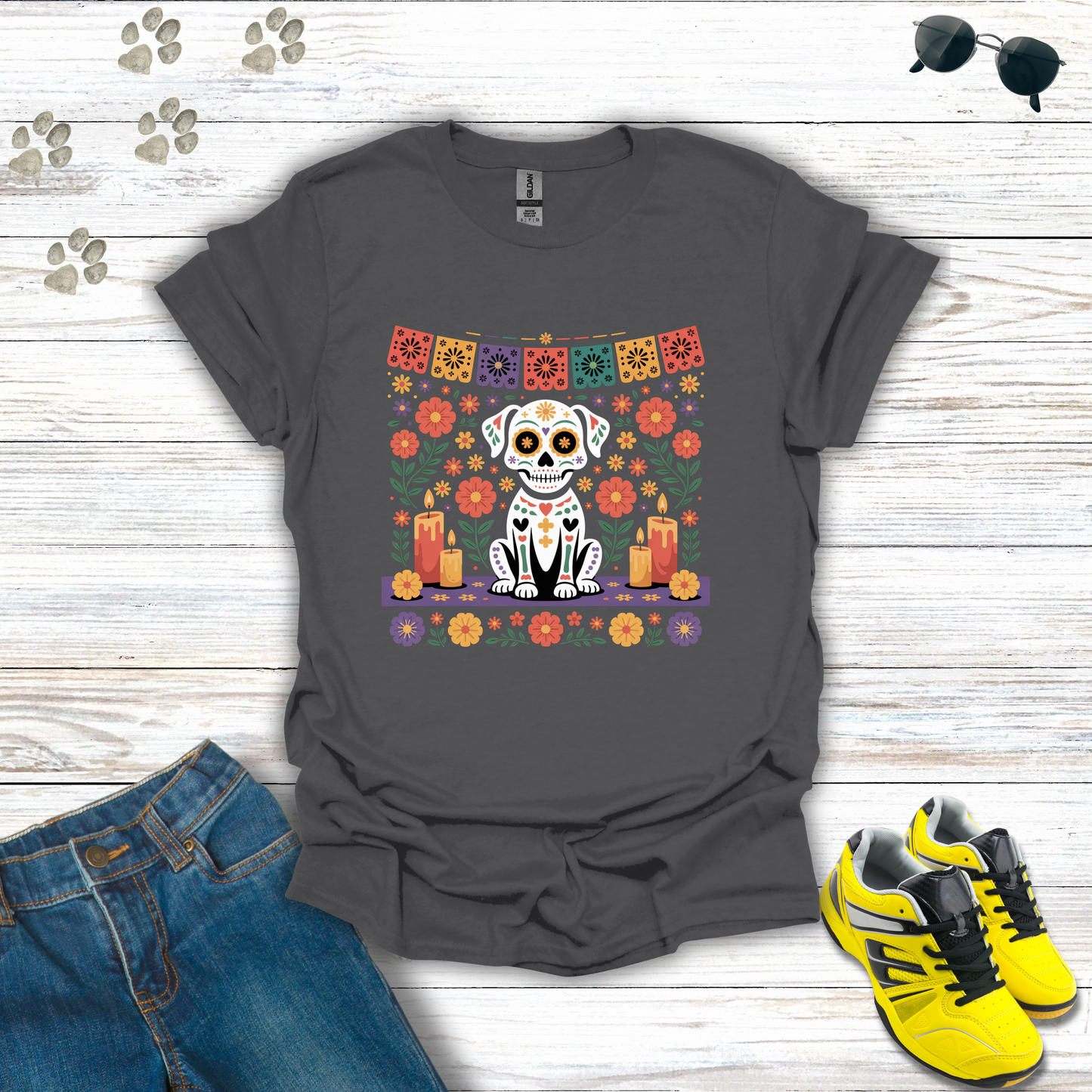 Charcoal t-shirt with a colorful dog skeleton design on a wooden surface with jeans and sneakers.