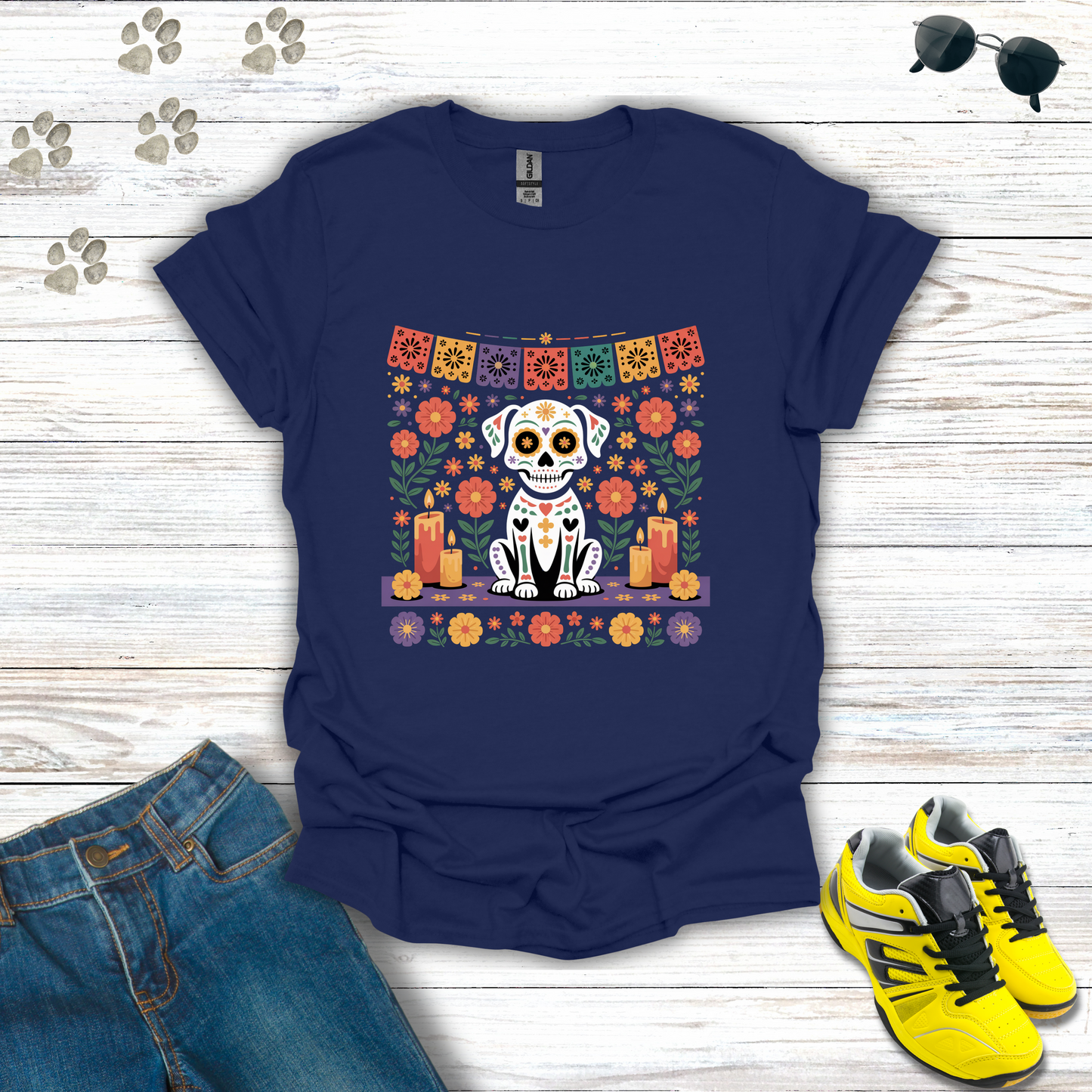 Navy blue t-shirt with a dog skull design on a wooden surface with jeans and sneakers.