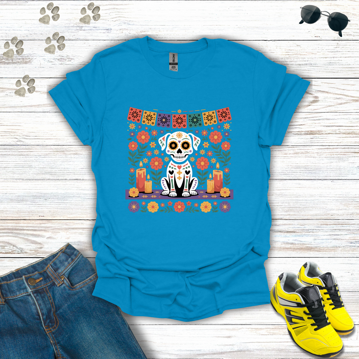 Sapphire Blue t-shirt with a dog and floral design on a wooden surface with jeans and shoes.