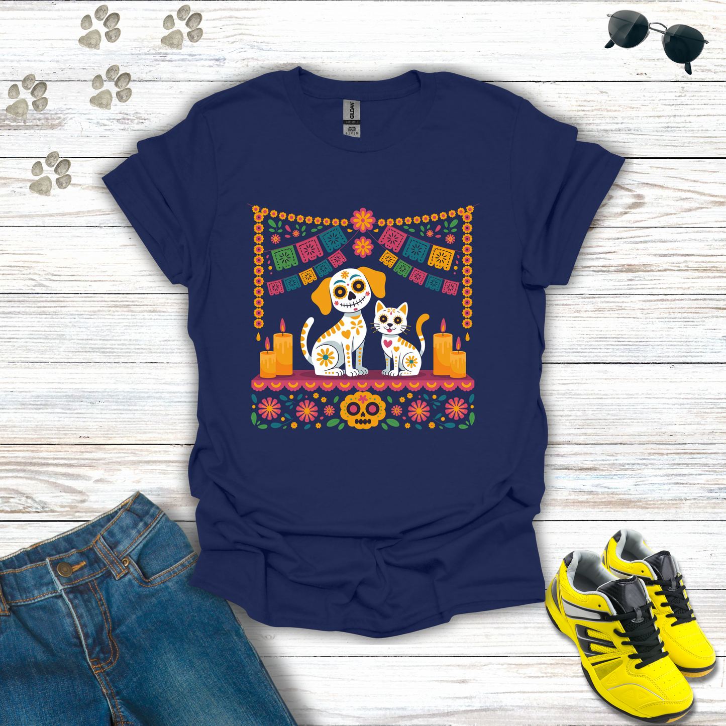 Navy blue t-shirt with a colorful graphic of two dogs and a cat on a wooden surface with jeans and sneakers.