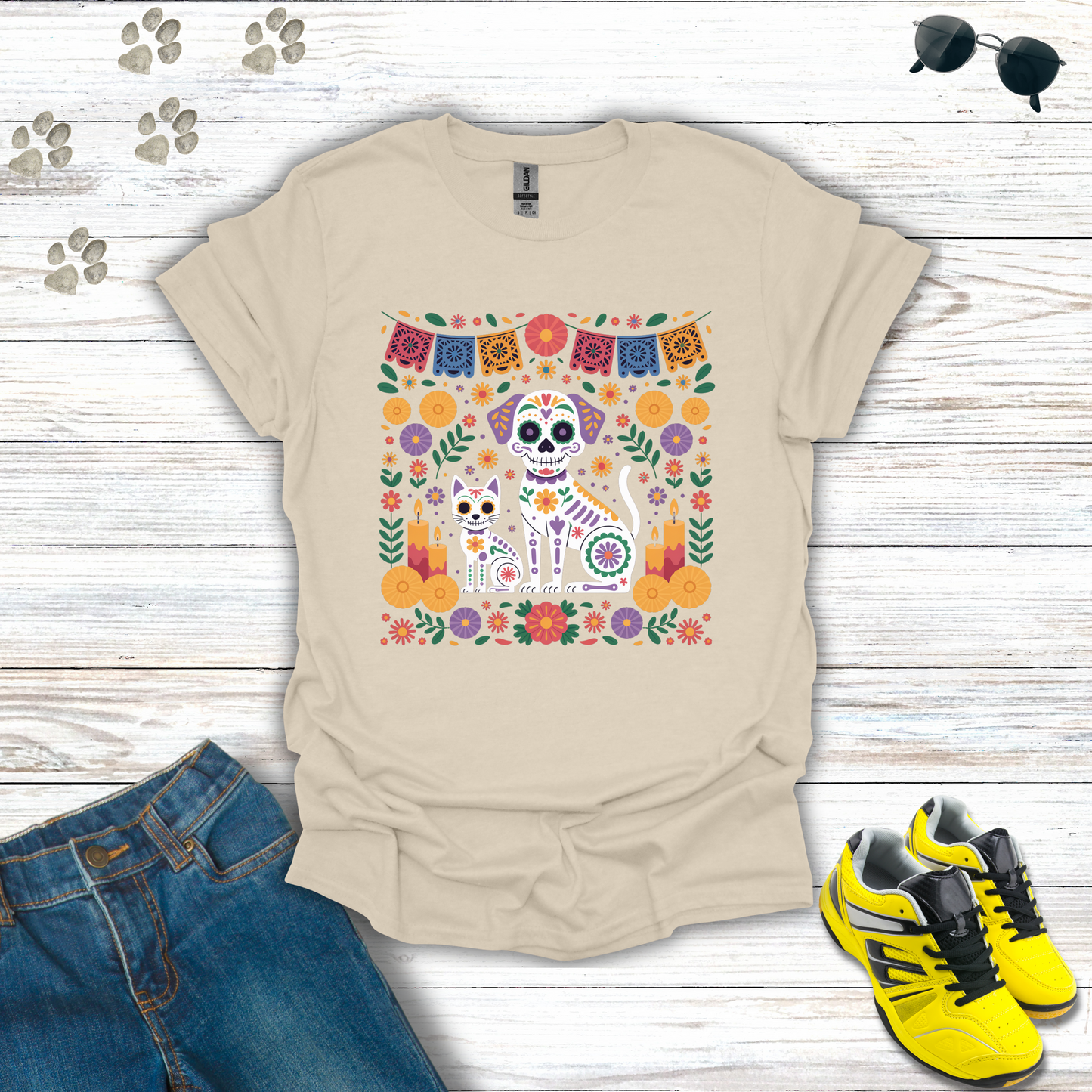Natural t-shirt with a colorful skull design on a wooden surface with jeans and sneakers.