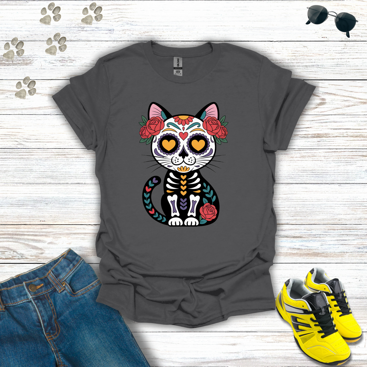 Charcoal t-shirt with a colorful cat skeleton design on a wooden surface with jeans and sneakers.