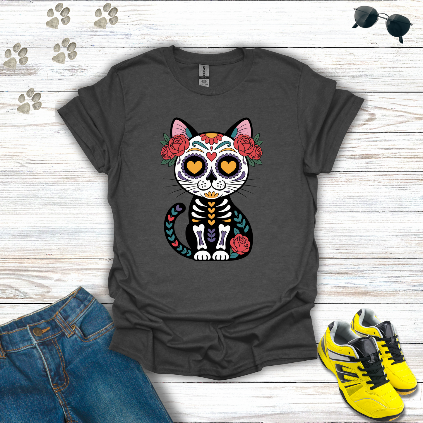 Dark Heather t-shirt with a colorful cat skeleton design on a wooden surface with jeans and sneakers.