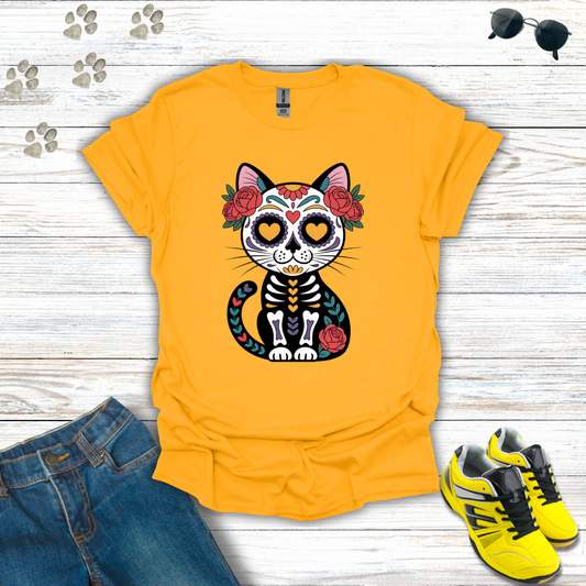 Gold t-shirt with a cat skeleton design on a wooden surface with jeans and shoes.