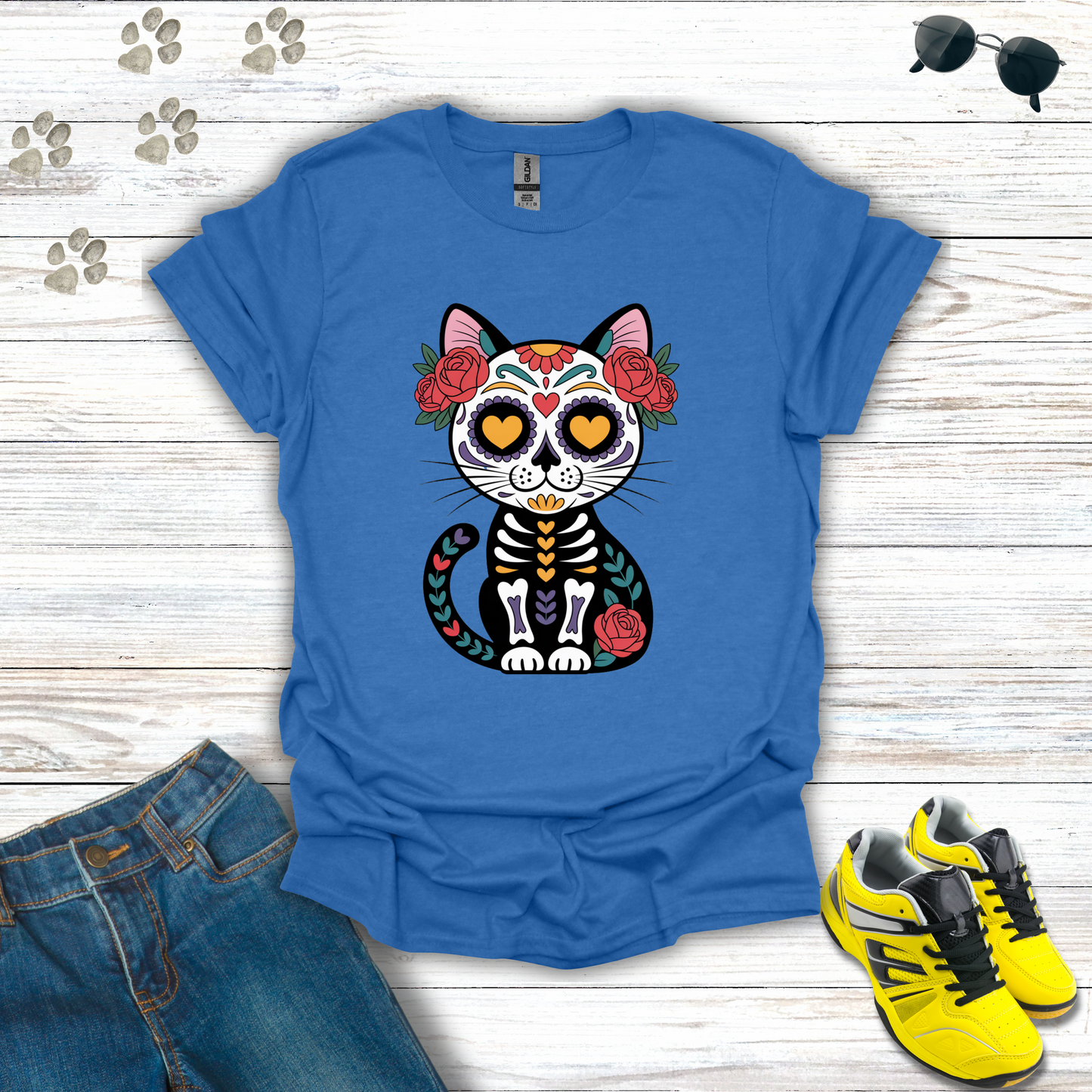 Heather Royal  t-shirt with a cat skeleton design on a wooden surface with jeans and shoes.