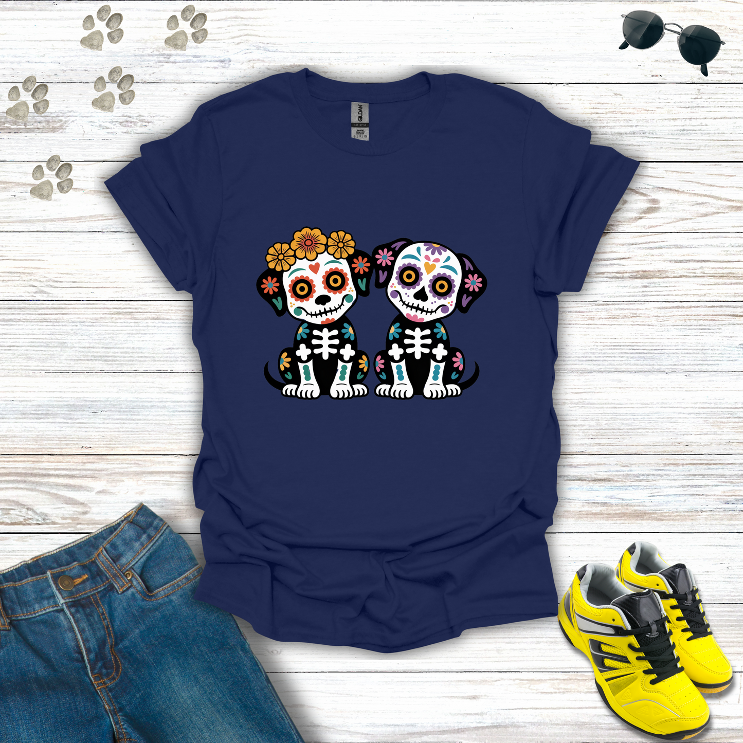 Navy blue t-shirt with skull design on a wooden surface with jeans and sneakers.