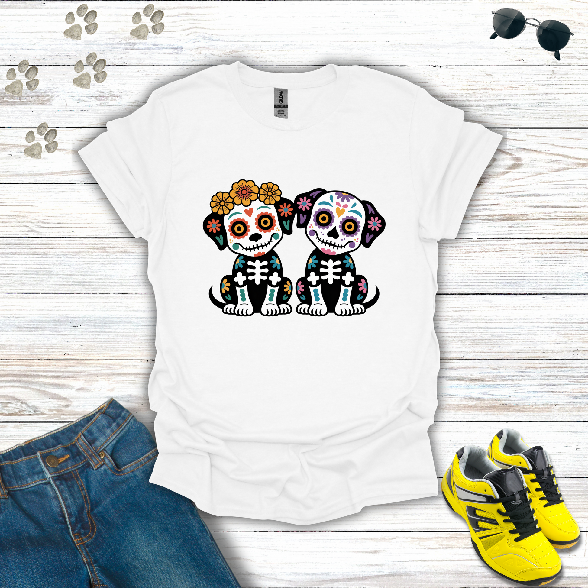 White t-shirt with skeleton dog design on a wooden surface with jeans and shoes.
