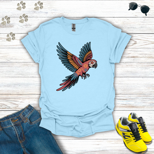 Light blue t-shirt with a parrot design on a wooden surface with jeans and sneakers.