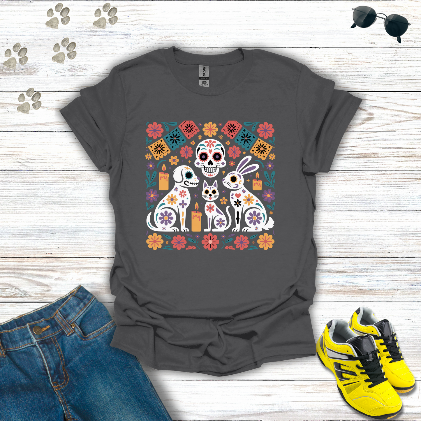 Charcoal t-shirt with colorful graphic design of dogs and flowers on a wooden surface with jeans and sneakers.
