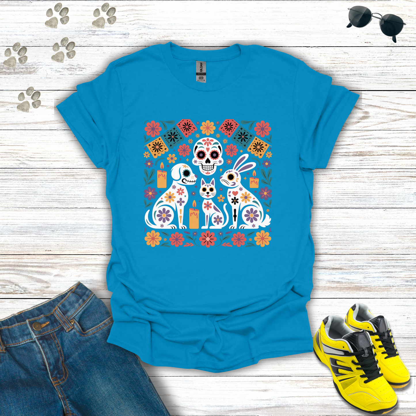 Sapphire t-shirt with colorful graphic design on a wooden surface with jeans and shoes.