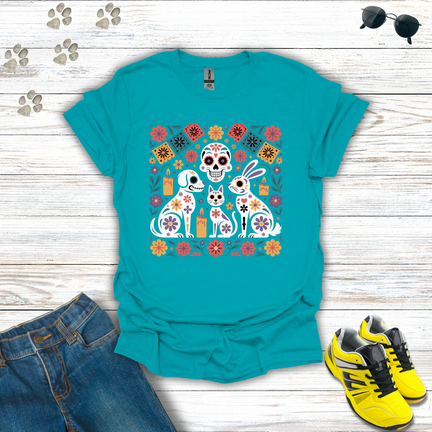 Tropical Blue t-shirt with a colorful graphic design on a wooden surface with jeans and sneakers.