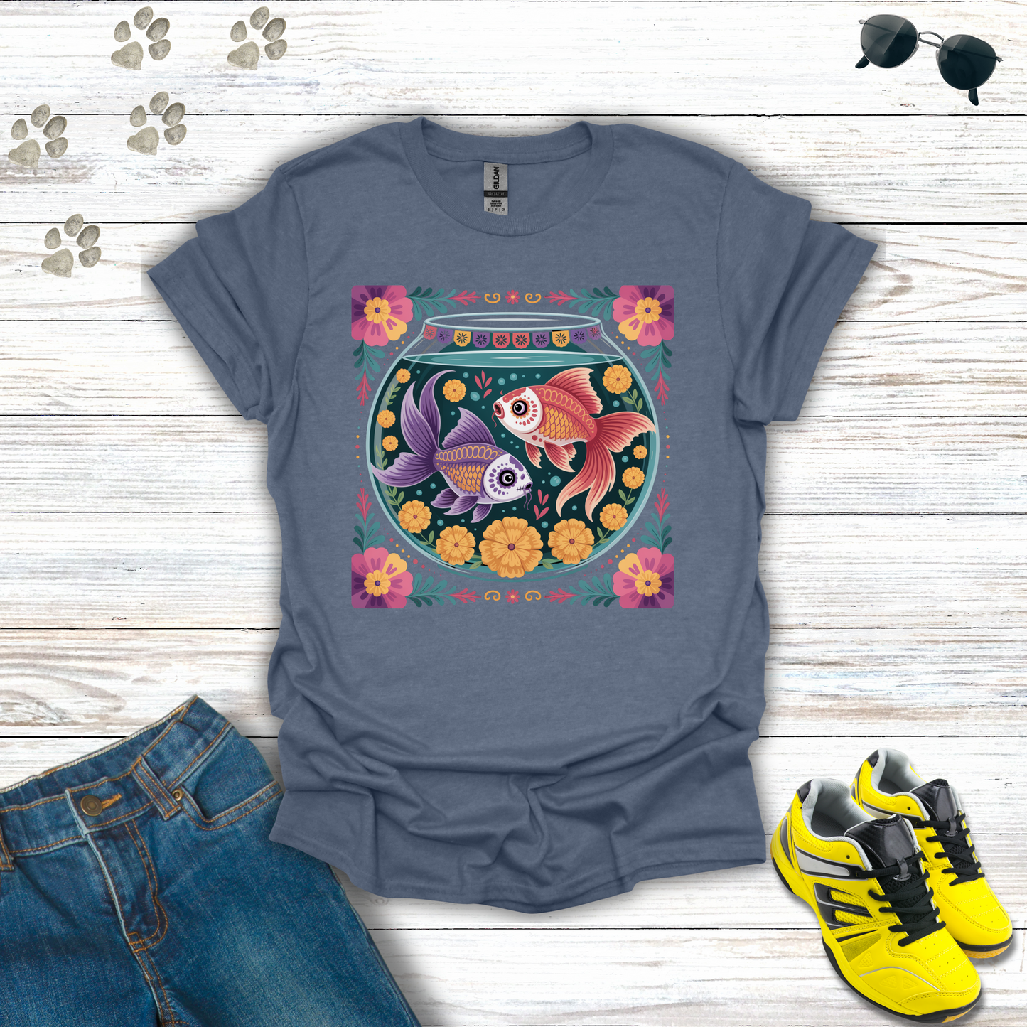 Heather Indigo t-shirt with fish bowl design on a wooden surface with jeans and sneakers.