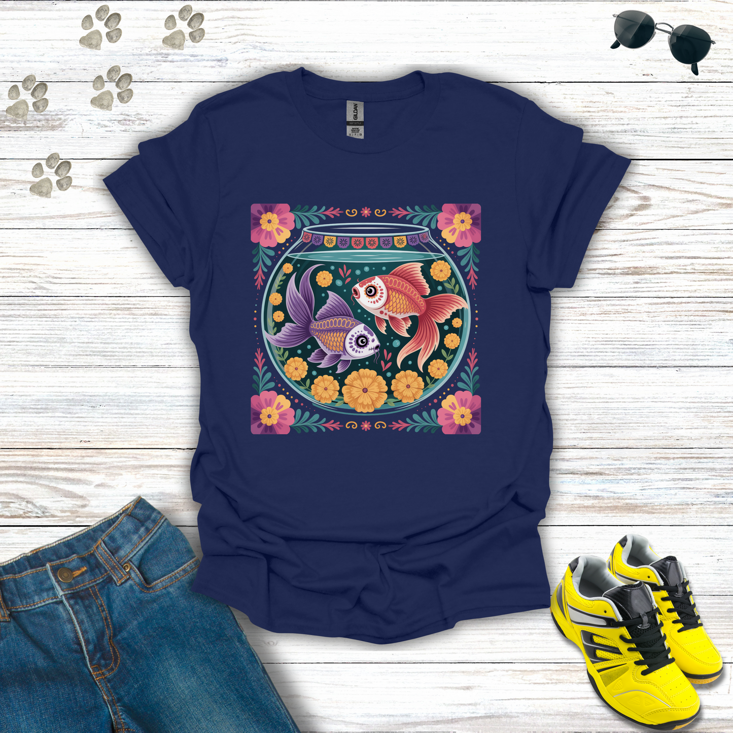 Navy blue t-shirt with fish bowl design on a wooden surface with jeans and sneakers.