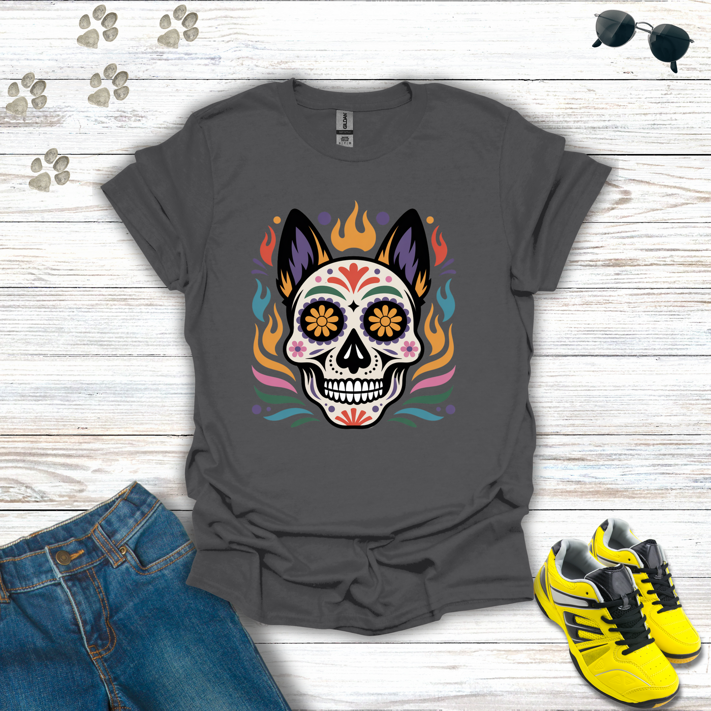 Charcoal t-shirt with colorful skull design on a wooden surface with jeans and sneakers.