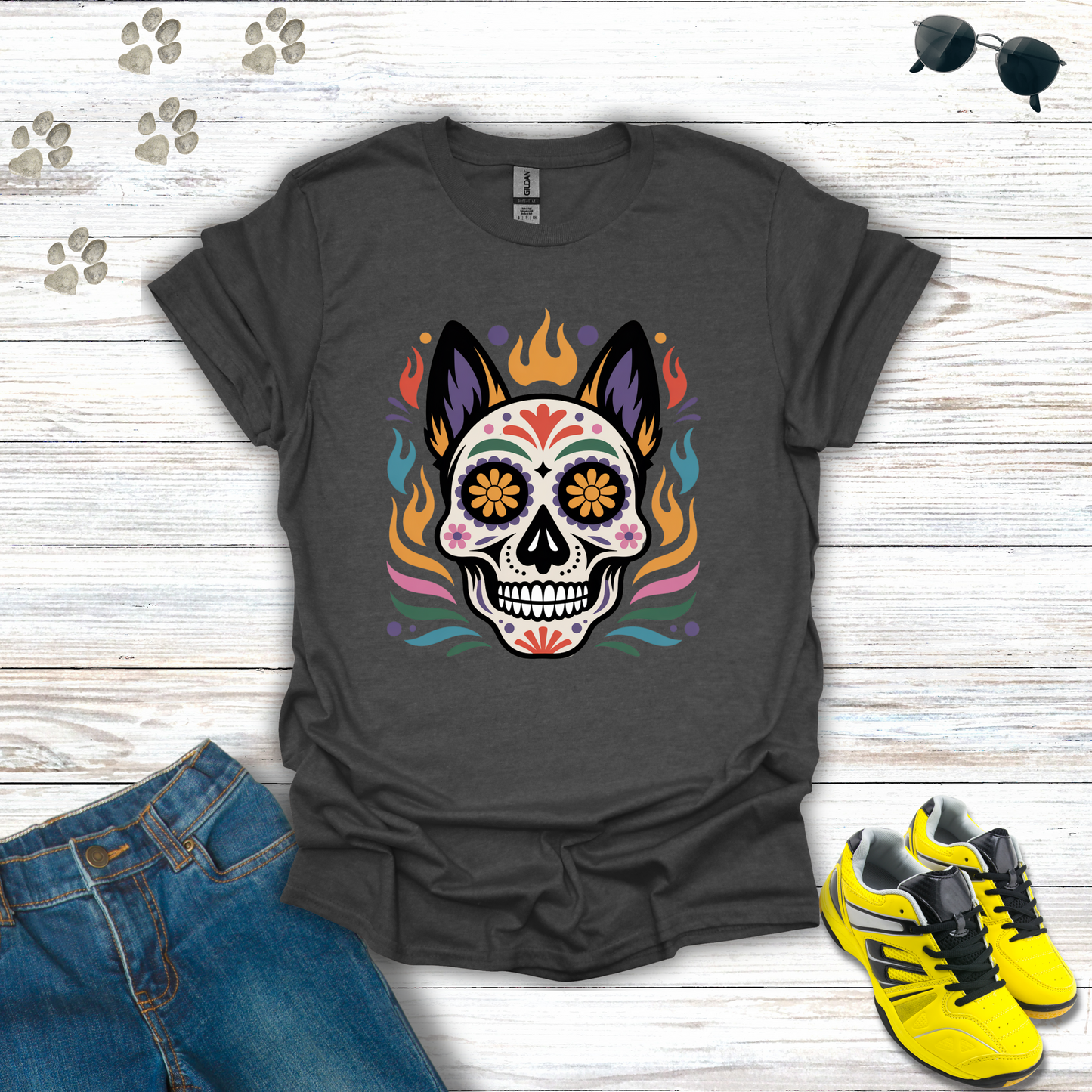 Dark Heather t-shirt with colorful skull design on a wooden surface with jeans and sneakers.