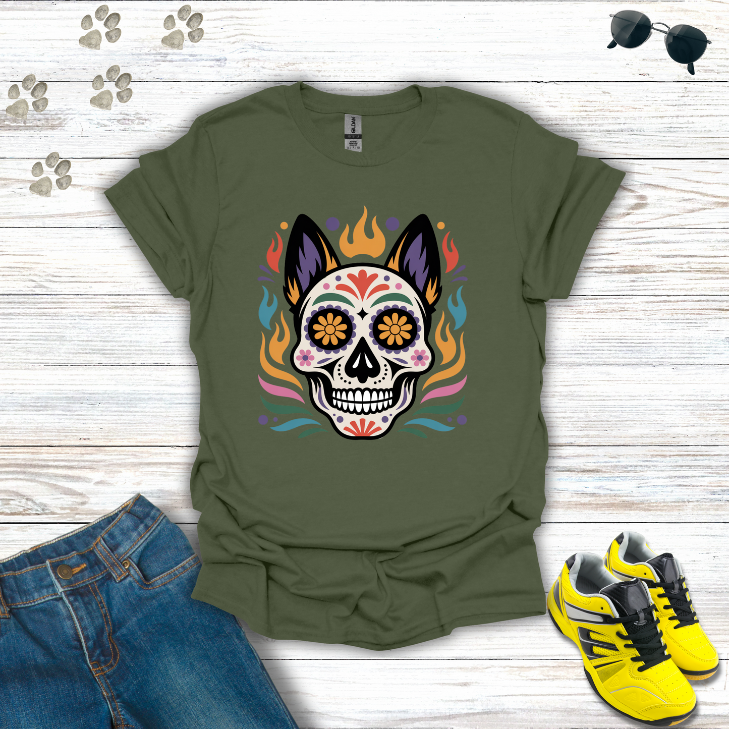 Military Green t-shirt with colorful skull design on a wooden surface with jeans and sneakers.