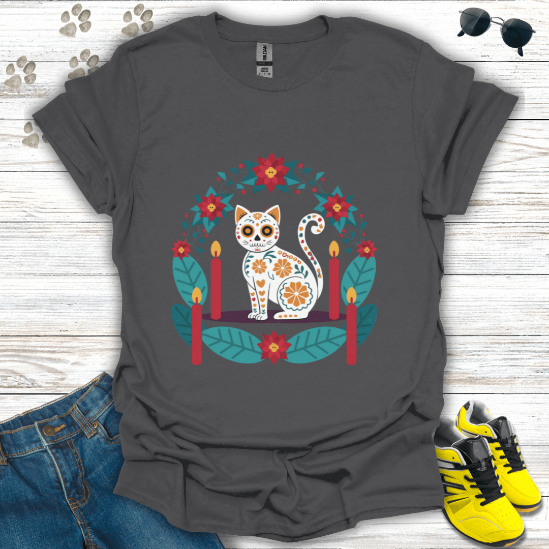 Christmas Sugar Skull Cat T-Shirt on charcoal Gildan tee featuring a sugar-skull white cat with poinsettias and glowing candles — cozy holiday folk-art design for cat lovers.