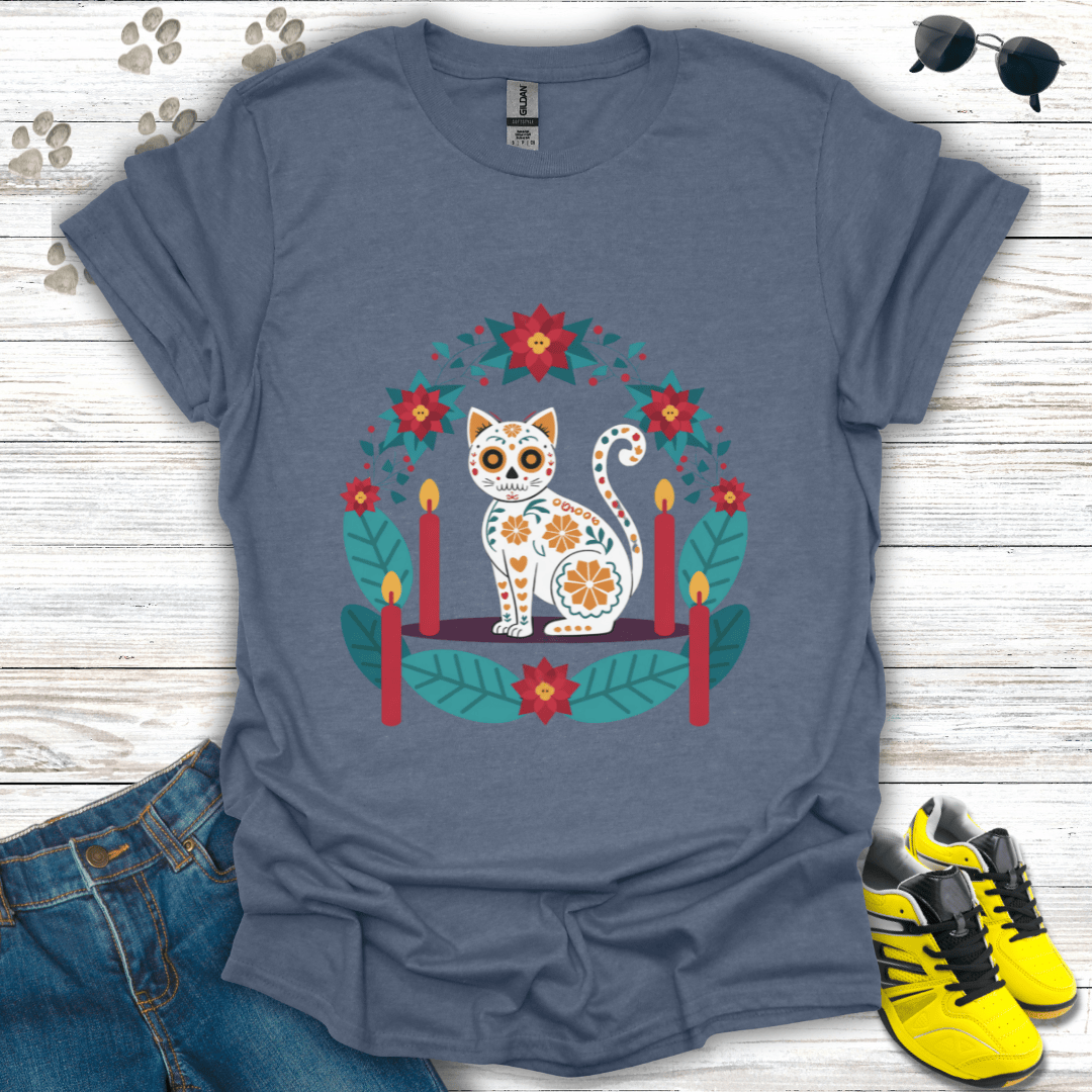 Christmas Sugar Skull Cat T-Shirt on heather indigo Gildan tee showing a white sugar-skull cat surrounded by teal leaves and red poinsettias — vibrant Christmas folk-art design.